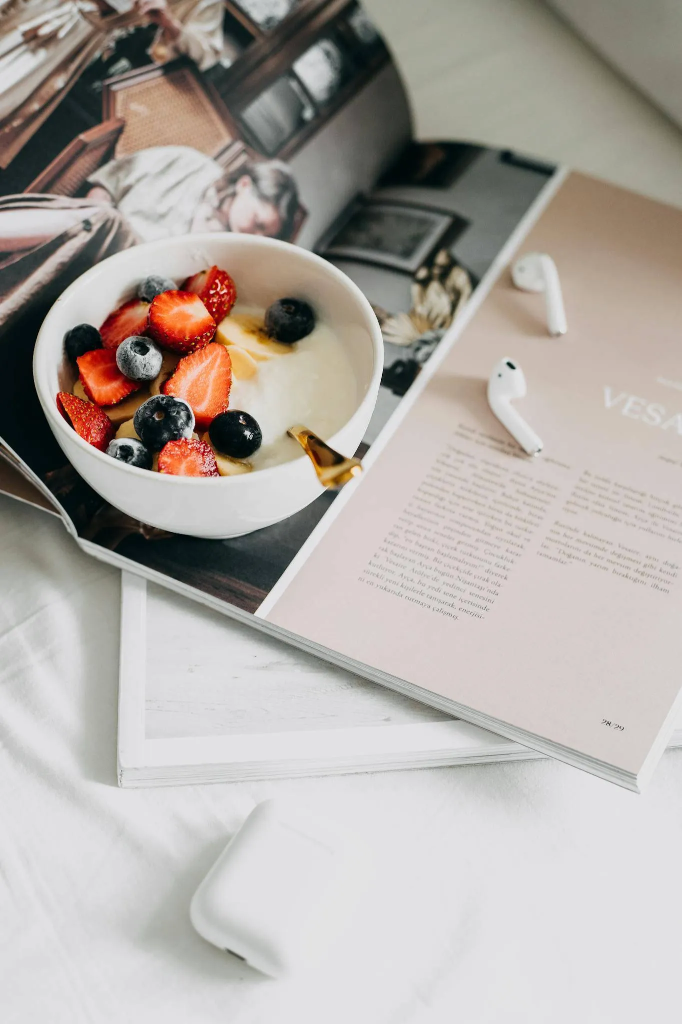 Fresh berries and yogurt bowl on a magazine, a perfect healthy breakfast.